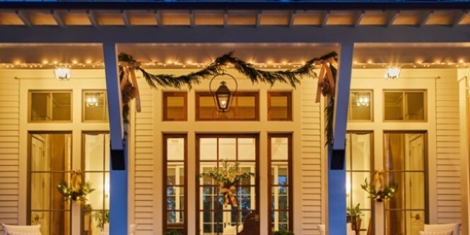 This front porch or veranda is decorated beautifully with Christmas trimmings and lights.
