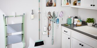 Maximise your vertical space by using wall hooks with different weight capacities to neatly organize pet supplies and cleaning tools.
