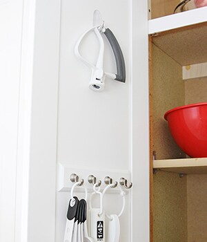 Following package instructions, apply one Command™ Medium Clear Hook to the inside of cabinet door

