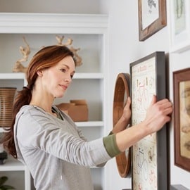 Woman arranging her artwork at eye level