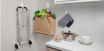 Shopping cart and a bag full of groceries hung on the wall with Command heavyweight hooks
