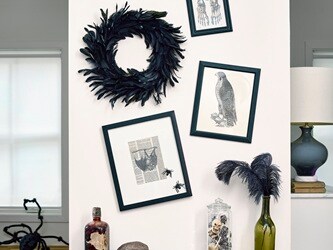 Create a Halloween-themed wall collage featuring a black wreath, crow, and bat prints hung with no-drill Command™ Picture Hanging Strips and Clear Hooks.
