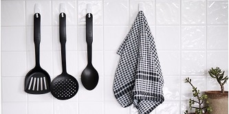 Cooking utensils and cleaning cloths hung on the wall with Command hooks
