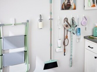 Maximise your vertical space by using wall hooks with different weight capacities to neatly organize pet supplies and cleaning tools.
