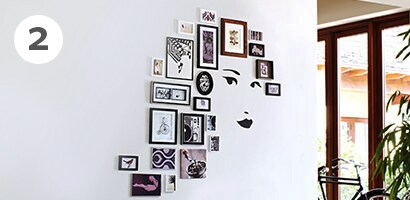 Picture frames surrounding the face decal as a unique gallery wall idea
