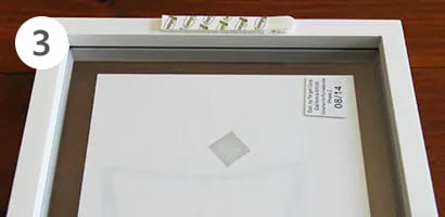 Applying command picture hanging strip to the back of the frame
