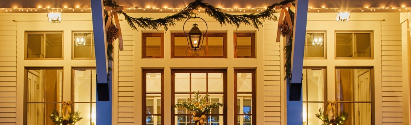 Christmas wreaths and string lights are arranged in the patio using Command outdoor clear window hooks and light clips
