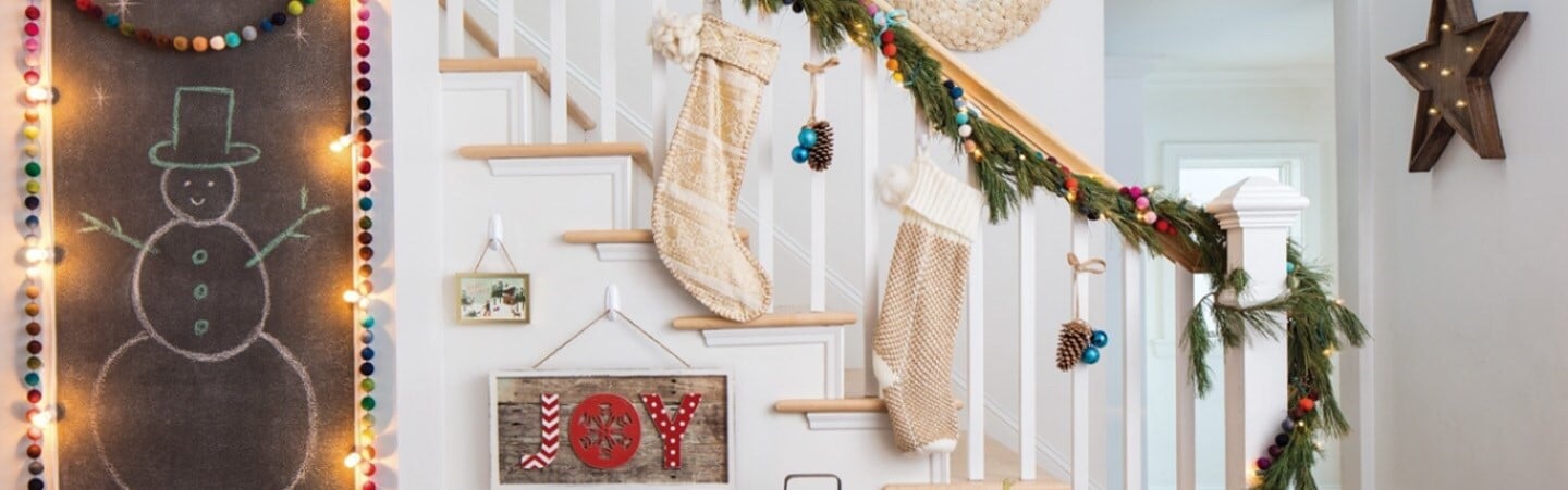 A festive staircase decorated with Christmas ornaments using Command hooks.
