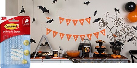 Create a festive Halloween background without drilling: hang paper bats and orange banners using Command™ Clear Decorating Clips.
