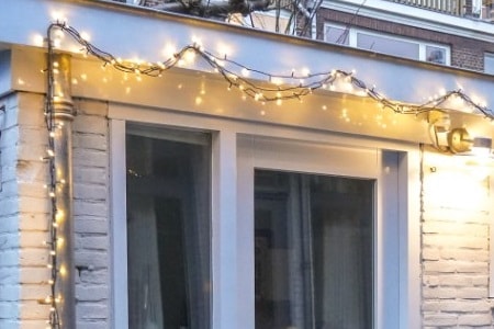 Christmas lights attached to the pipes, gutter, and roof, using Command clips
