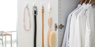 Jewellery, belts, and brush hung on the closet door with Command wire hooks
