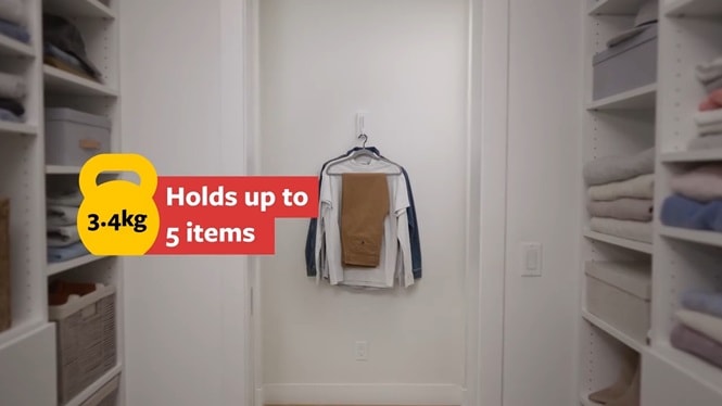 A Command folding clothes hanger is mounted on the closet wall, holding various outfits.
