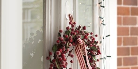 Berry-filled wreath hanging by the window with Command Clear Hook
